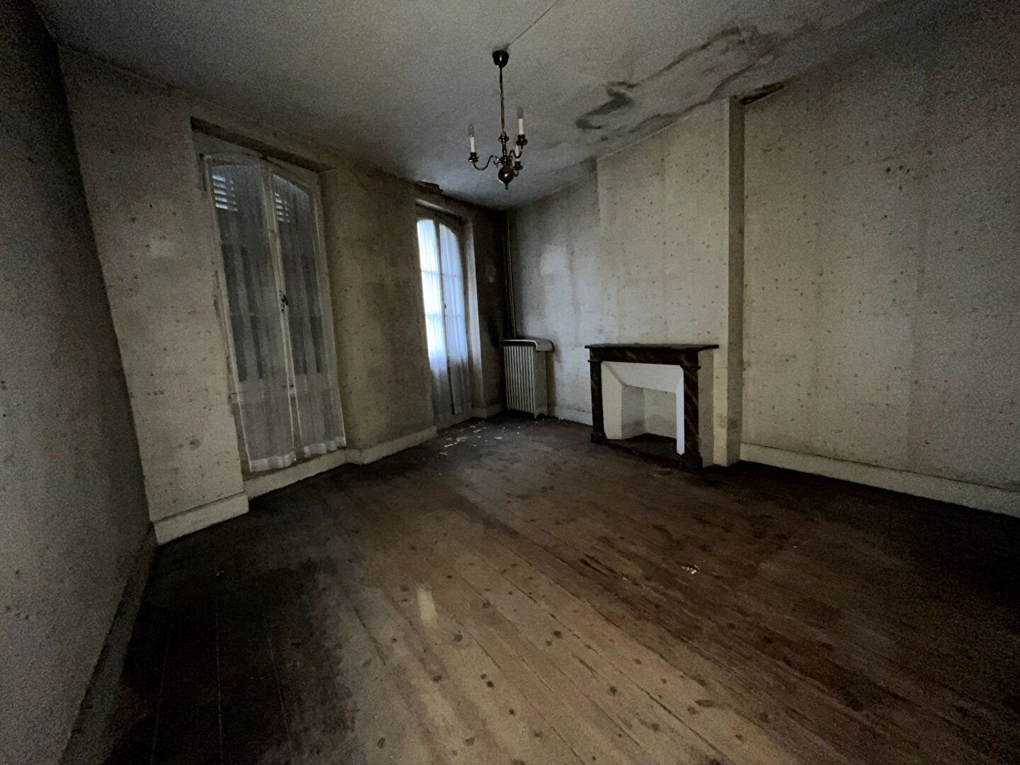 Photo A Villeneuve sur Lot, maison de ville à rénover d'une surface d'environ 73,18m² avec  jardin d'environ 100 m² .  Cette maison, nous offre au rez-de-chaussée un couloir de 8,81m² desservant un salon de 12,29m², une cuisine de 14,27m² donnant sur le jardin. image 3/6