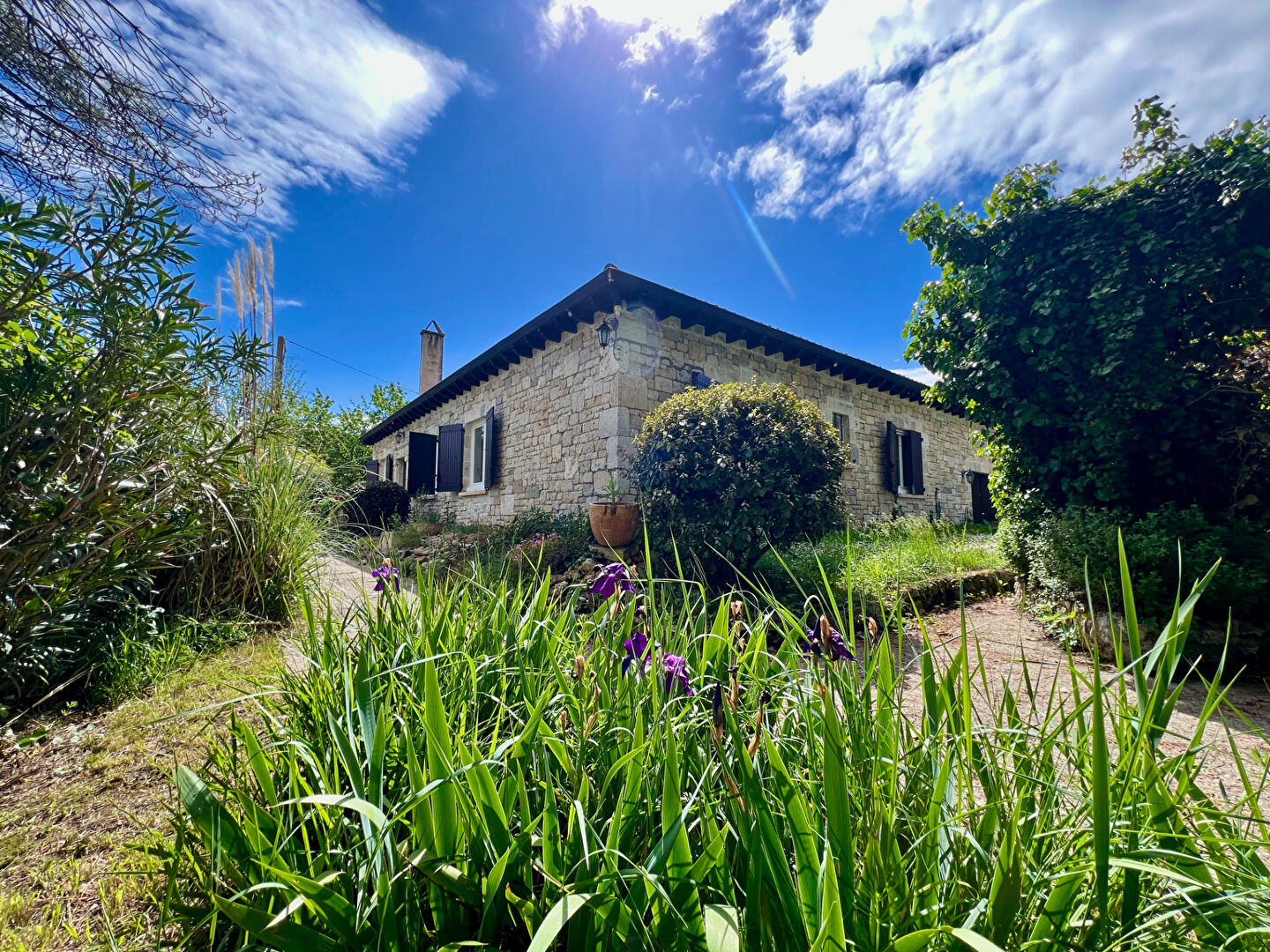 A PUJOLS, maison à vendre d'environ 150 m² en pierres de taille de plain-pied avec 4 chambres, grand terrain constructible de 4481 m² et hangar de 200 m²  proche de Villeneuve-sur-Lot. Cette authentique maison en pierres (atypique pour une maison construi