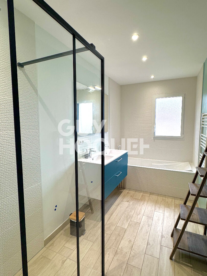 Maison contemporaine avec piscine chauffée et garage.