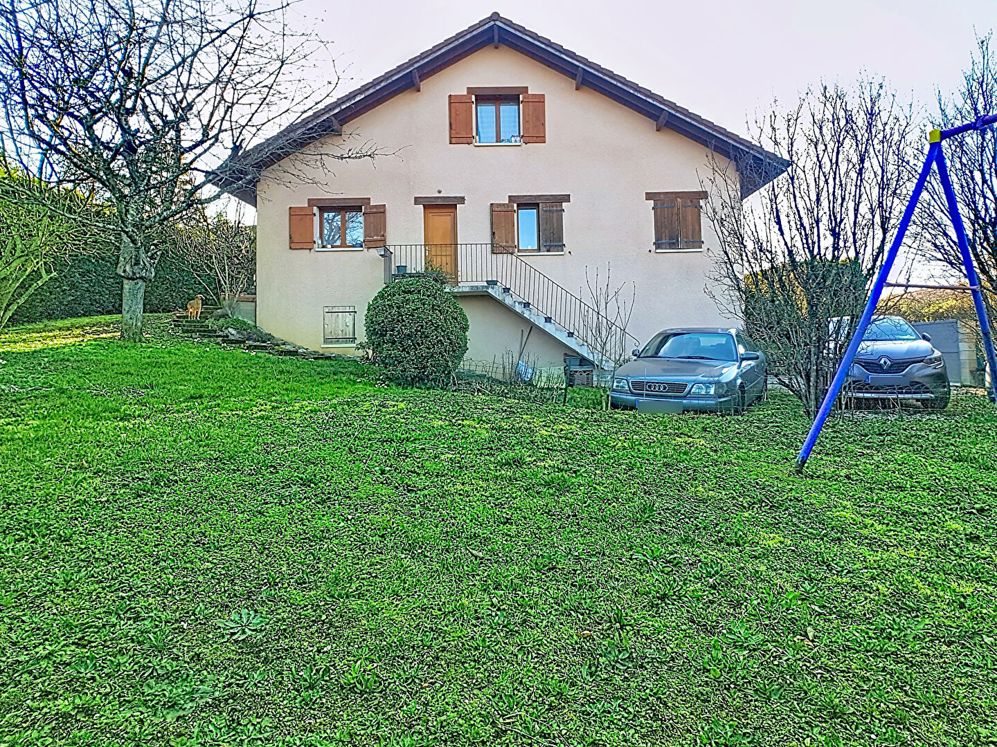 Spacious property in Haute-Savoie with garden, parking, and exterior stairs leading to the upper level.
