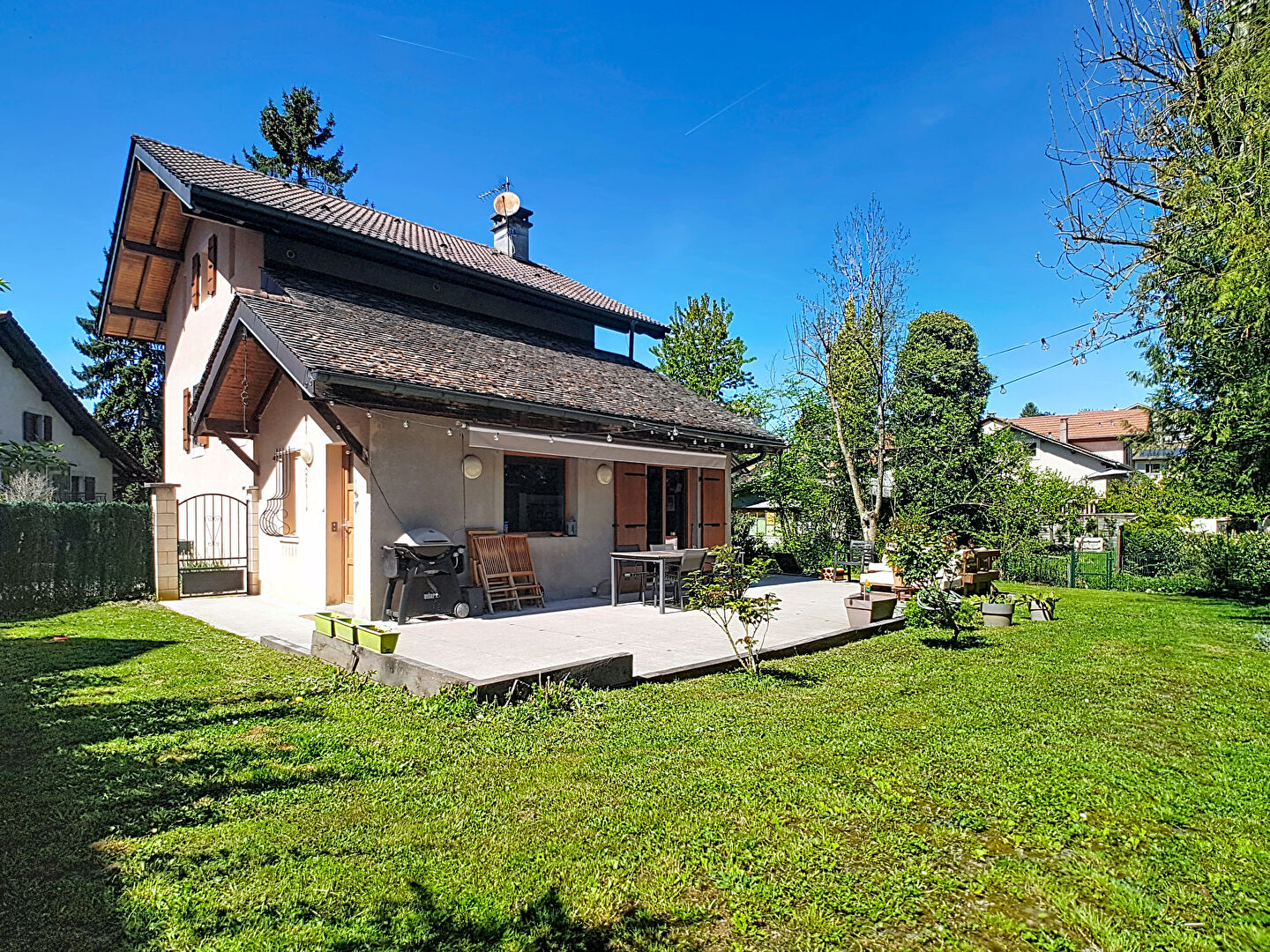 Modern property in Haute-Savoie featuring open-plan kitchen and dining area with wooden beams and stylish furnishings.