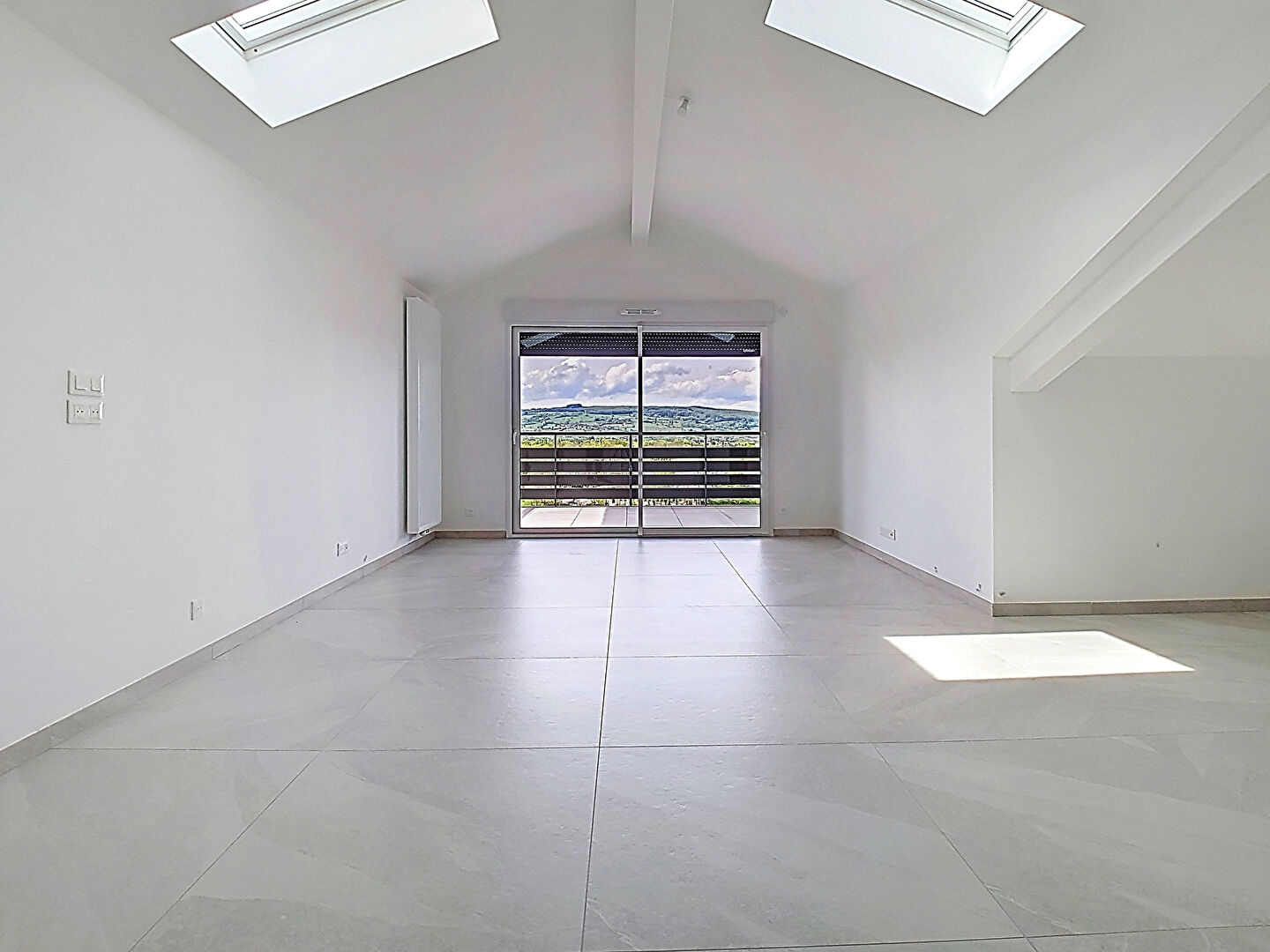 Spacious property in Haute-Savoie, featuring large windows and access to a balcony with scenic views.