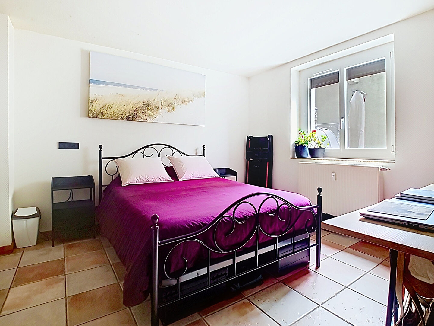 Three-bedroom property in Haute-Savoie featuring a simple bedroom with a bed, desk, and storage units.