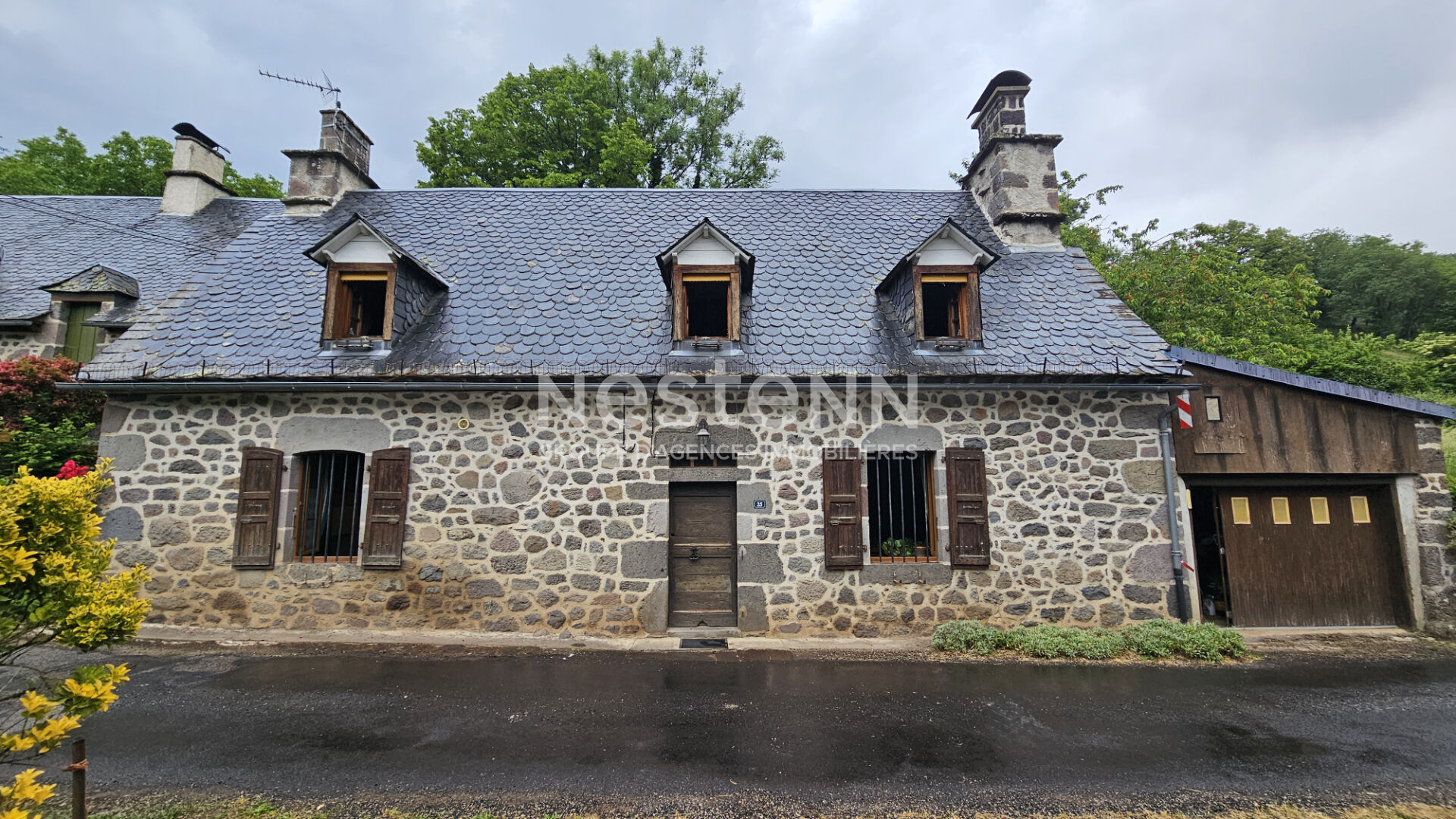 A vendre à Saint Martin Valmeroux, au coeur du pays de Salers, Maison avec garage et deux granges avec terrain.
