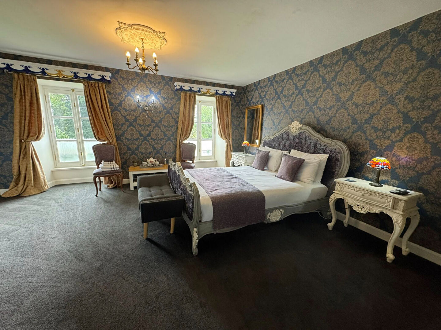 Elegant property in Haute-Vienne featuring a spacious bedroom with ornate decor and large windows.