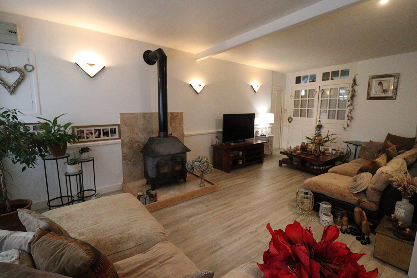 Spacious interior of a property in Corrèze, Nouvelle-Aquitaine, featuring a wood-burning stove and comfortable seating.