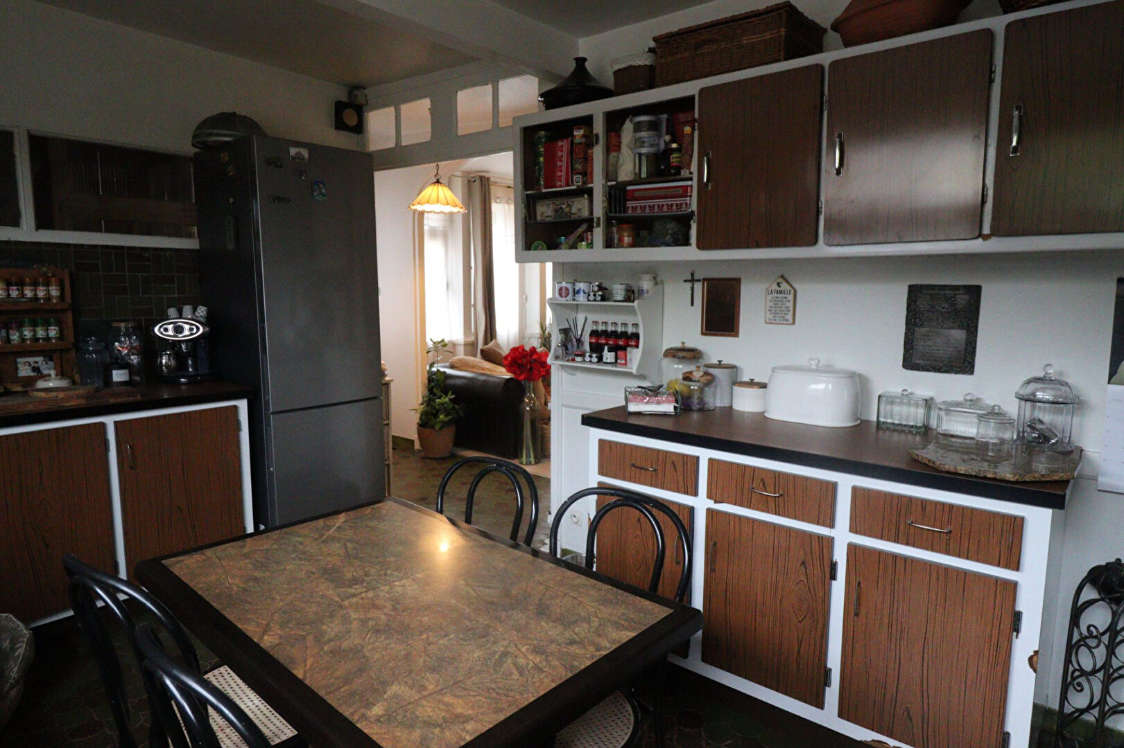 Spacious kitchen with wooden cabinets and dining area in a property located in Corrèze, Nouvelle-Aquitaine.