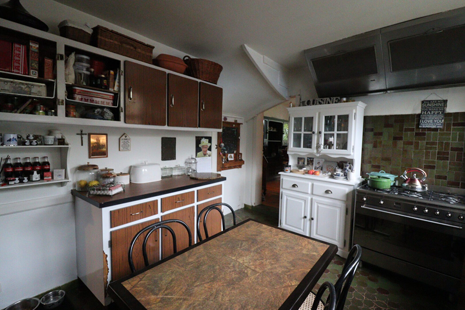 A kitchen featuring wooden cabinets, a dining table, and a stove in a property located in Corrèze, Nouvelle-Aquitaine.