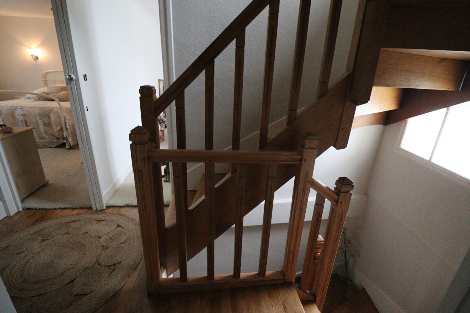 Staircase leading to a five-bedroom property in Corrèze, Nouvelle-Aquitaine, featuring wooden handrails and natural light.