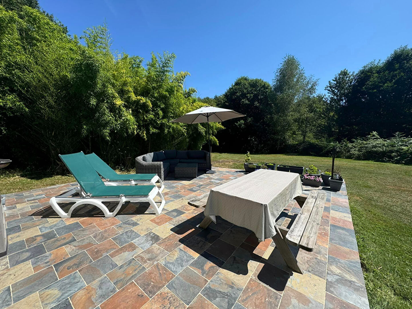 Spacious garden terrace with seating and sun loungers at property in Haute-Vienne, Nouvelle-Aquitaine.