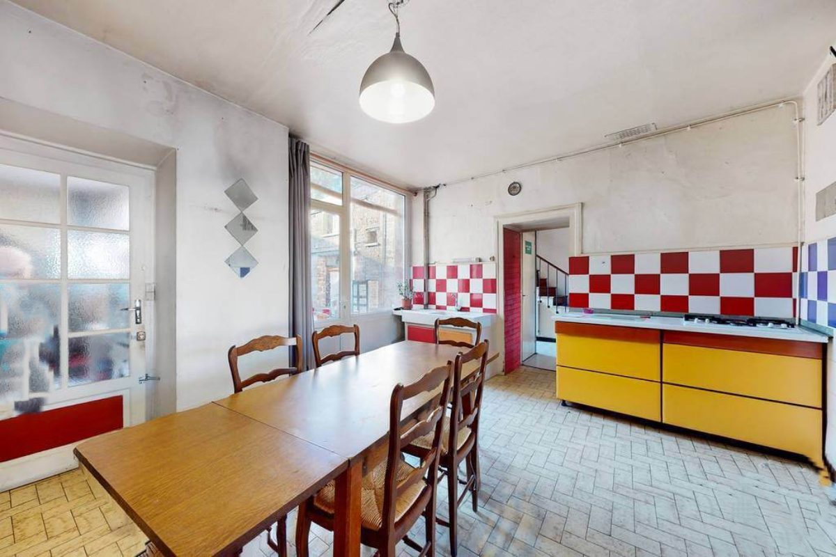 Spacious kitchen featuring a dining table, colourful tiles, and ample natural light in Creuse, Nouvelle-Aquitaine.