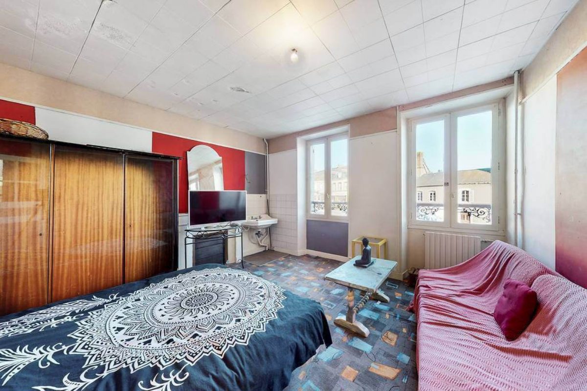 Spacious property in Creuse, Nouvelle-Aquitaine, featuring a large bedroom with a unique design and ample natural light.