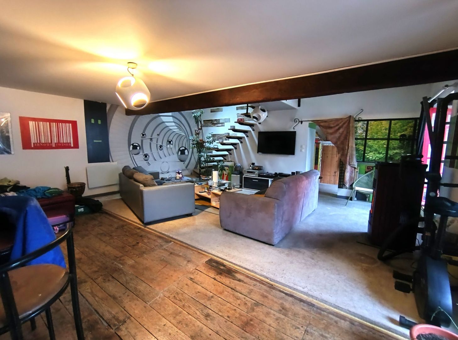 Spacious property in Creuse featuring a modern living area with large windows and wooden flooring.