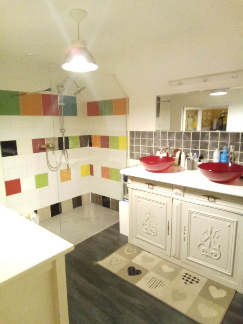 Bright bathroom featuring dual sinks, colourful tiles, and a walk-in shower in Creuse, Nouvelle-Aquitaine, 23300.