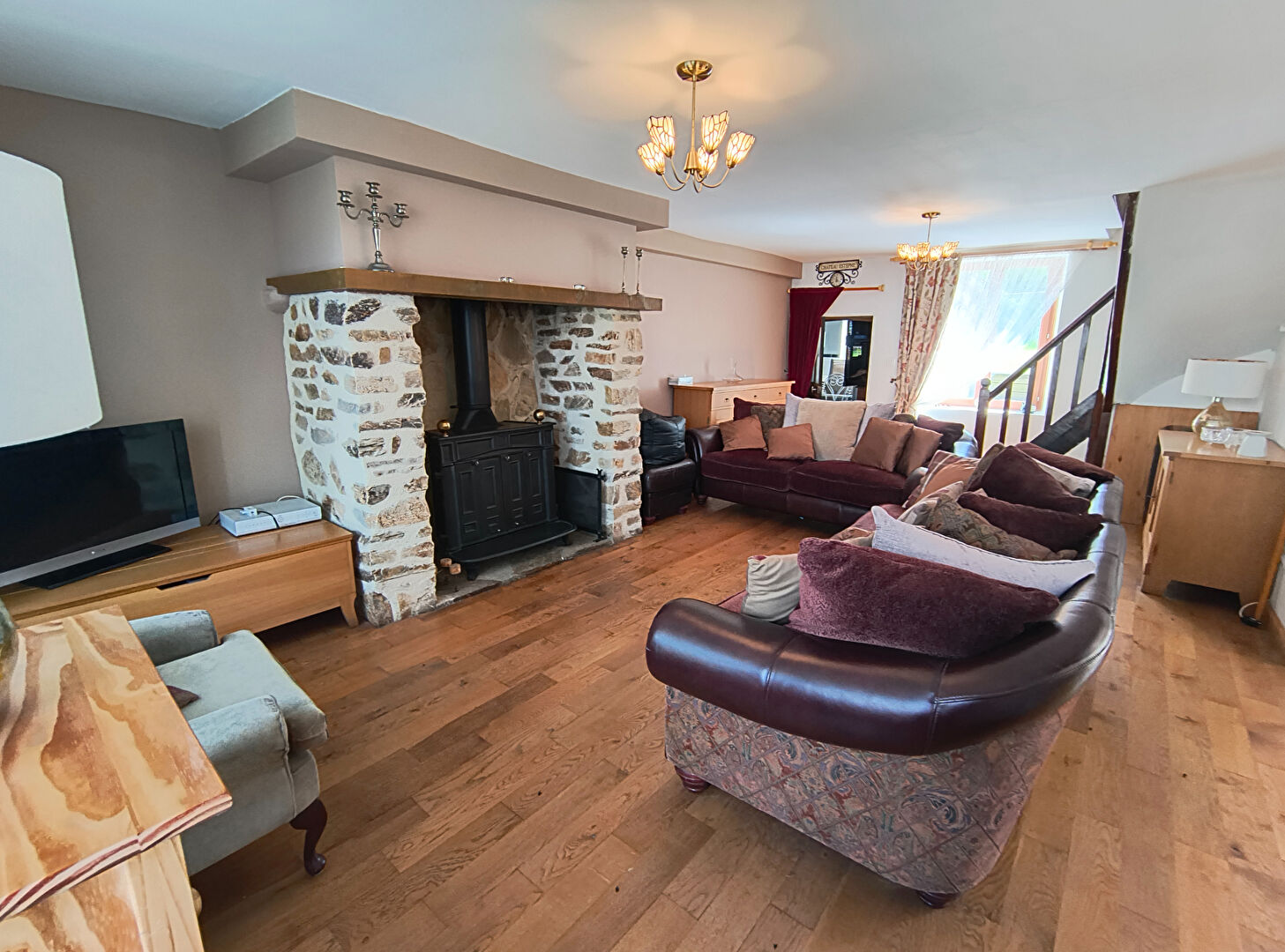 Spacious property in Creuse, Nouvelle-Aquitaine, featuring a cosy lounge with stone fireplace and wooden flooring.