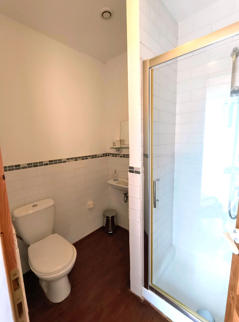 Modern bathroom featuring a shower and toilet in Creuse, Nouvelle-Aquitaine, with contemporary white tiles.