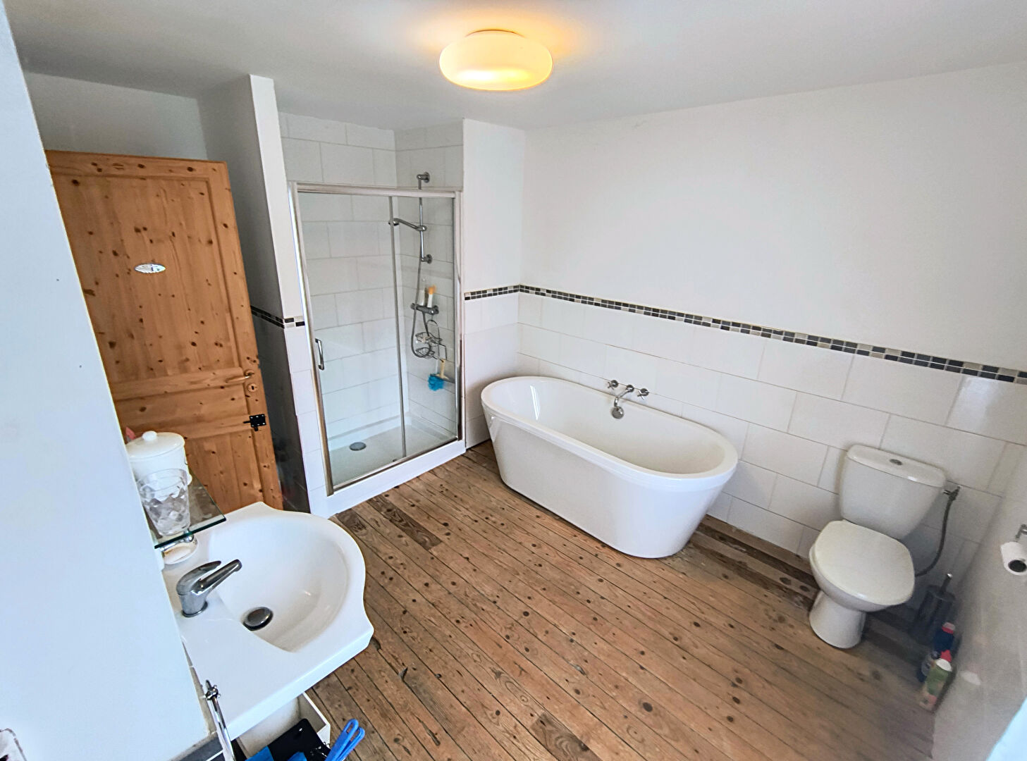 Spacious bathroom featuring a freestanding bath, shower, and wooden flooring in Creuse, Nouvelle-Aquitaine.