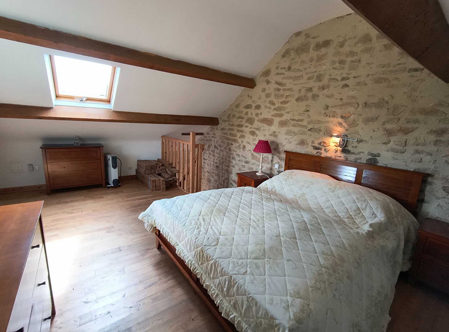 Spacious property in Creuse featuring a wooden beam ceiling and a comfortable bedroom with a double bed.