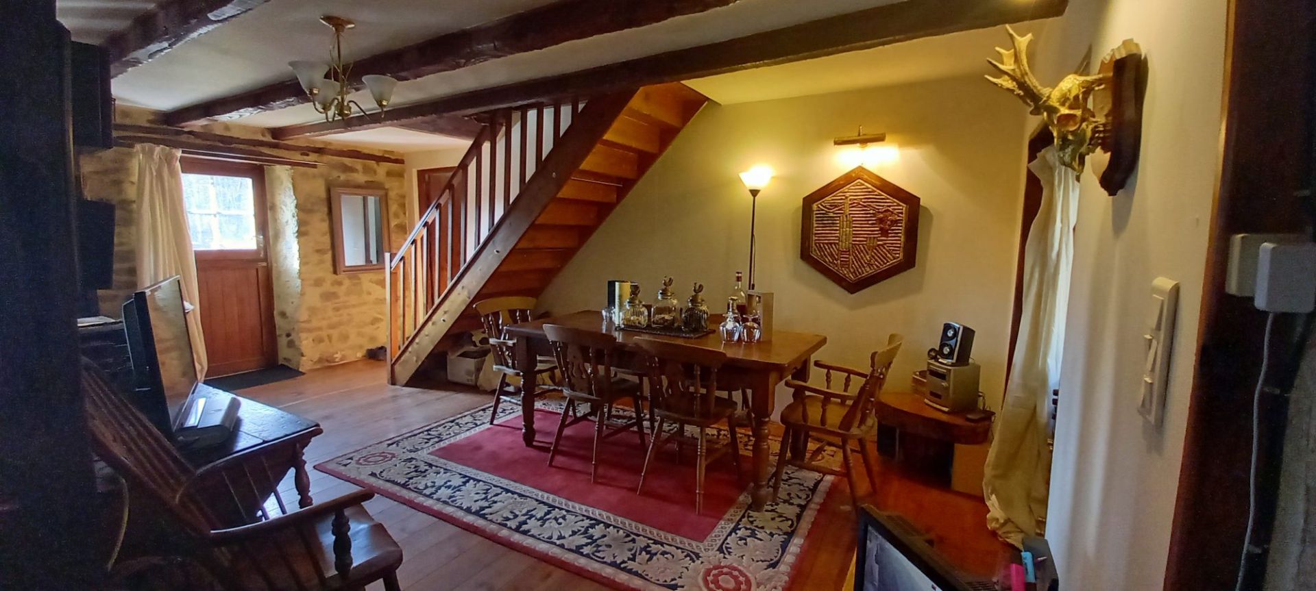 Elegant property in Haute-Vienne featuring a spacious dining area and wooden staircase in a charming interior.