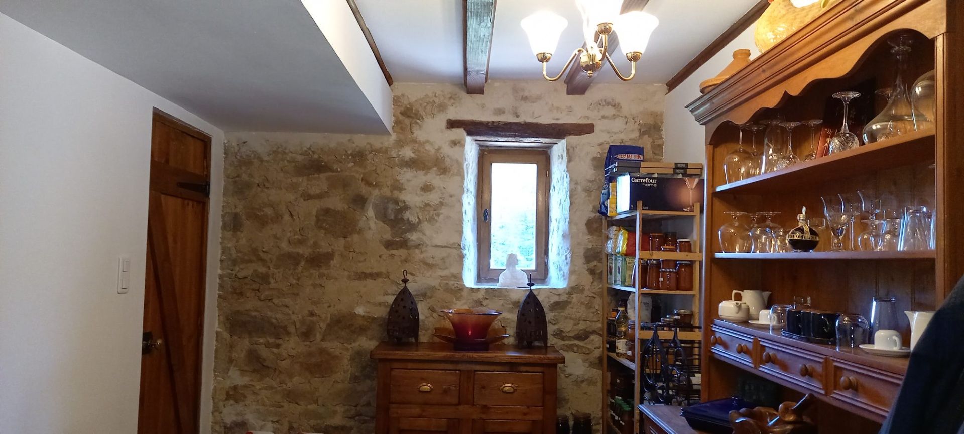 Rustic interior of a property in Haute-Vienne, Nouvelle-Aquitaine, featuring exposed stone walls and wooden shelving.