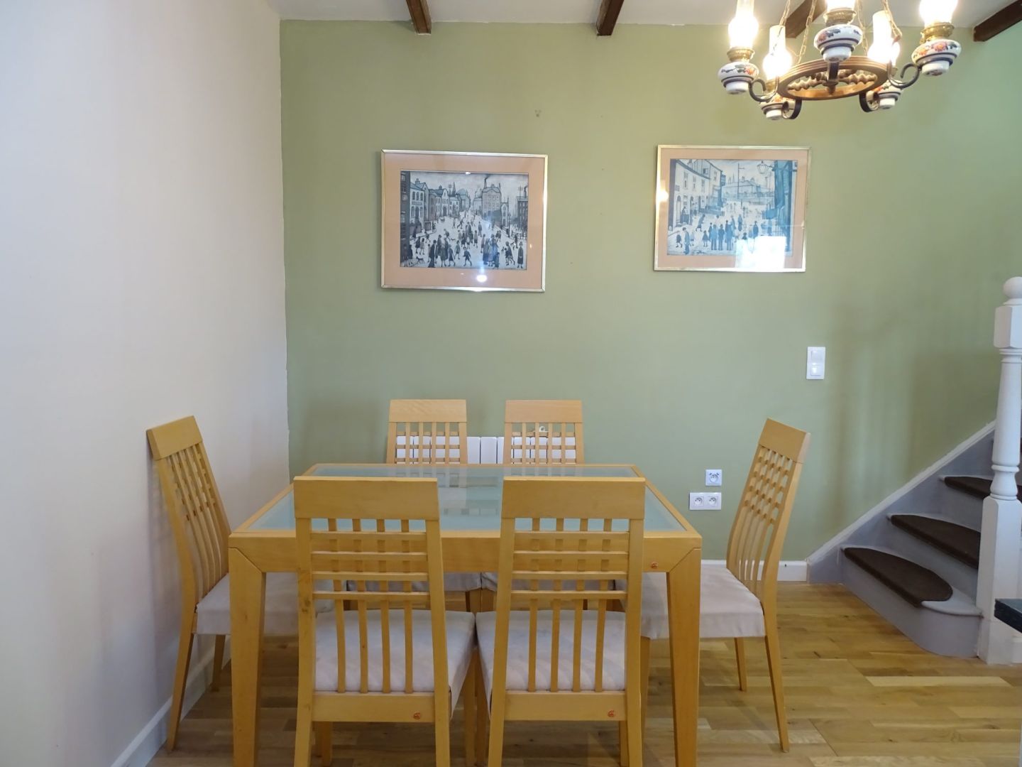 Dining area featuring a glass table and wooden chairs in a property located in Côtes-d'Armor, Brittany, 22110.
