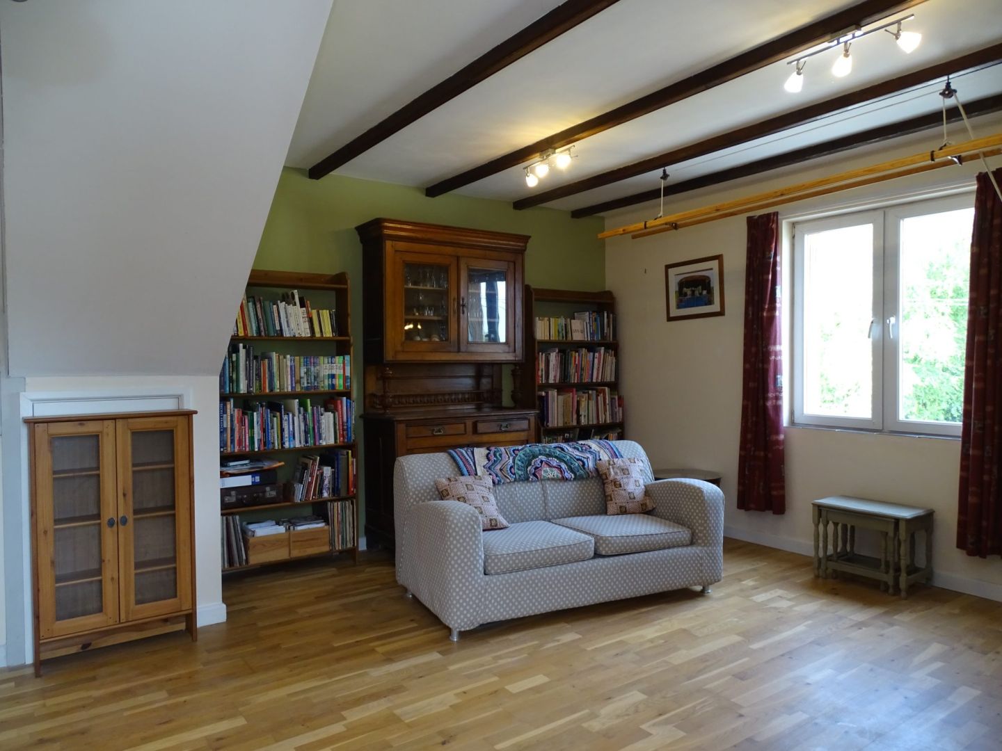 Spacious living area with wooden beams, bookshelves, and natural light in Côtes-d'Armor, Brittany. Property type: house.