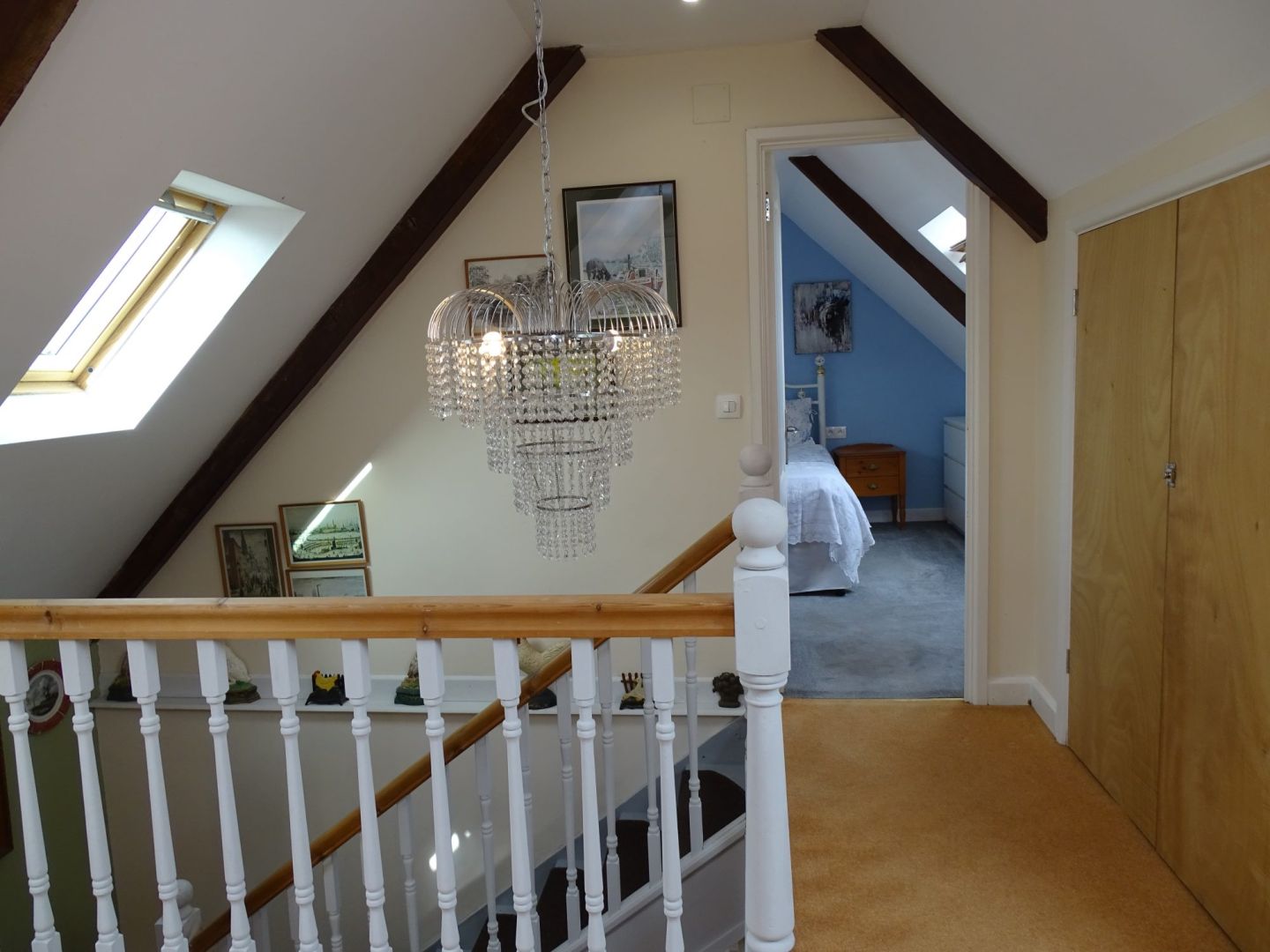 Spacious interior of a property in Côtes-d'Armor, featuring a chandelier and access to a bedroom.