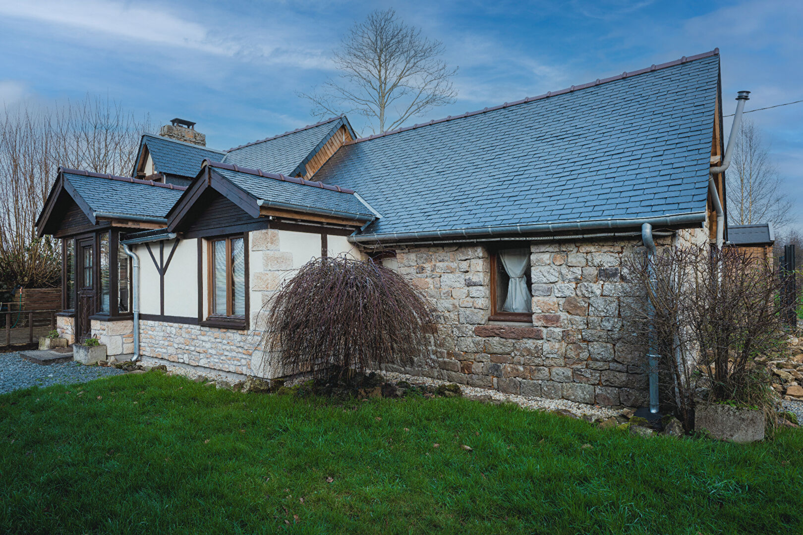 Charming property in Orne, Normandy, featuring a stone exterior, well-maintained garden, and traditional roofing.
