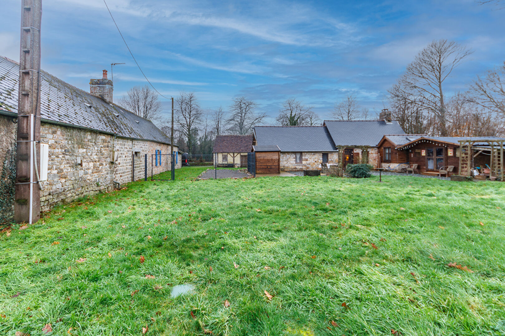 Property in Orne, Normandy, featuring a spacious garden and traditional stone architecture with multiple buildings.