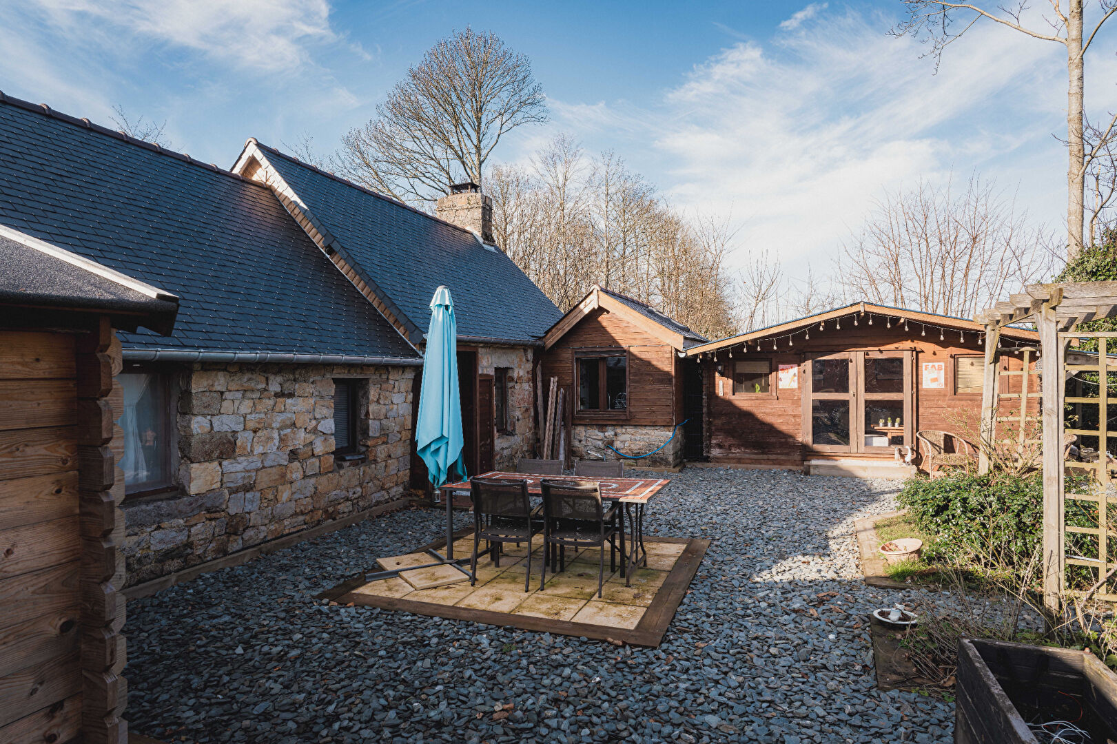 Charming property in Orne, Normandy, featuring a stone exterior, outdoor seating area, and scenic surroundings.