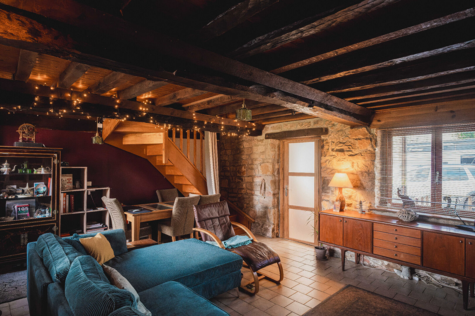 Cosy property in Orne, Normandy, featuring a warm living area with wooden beams and modern furnishings.