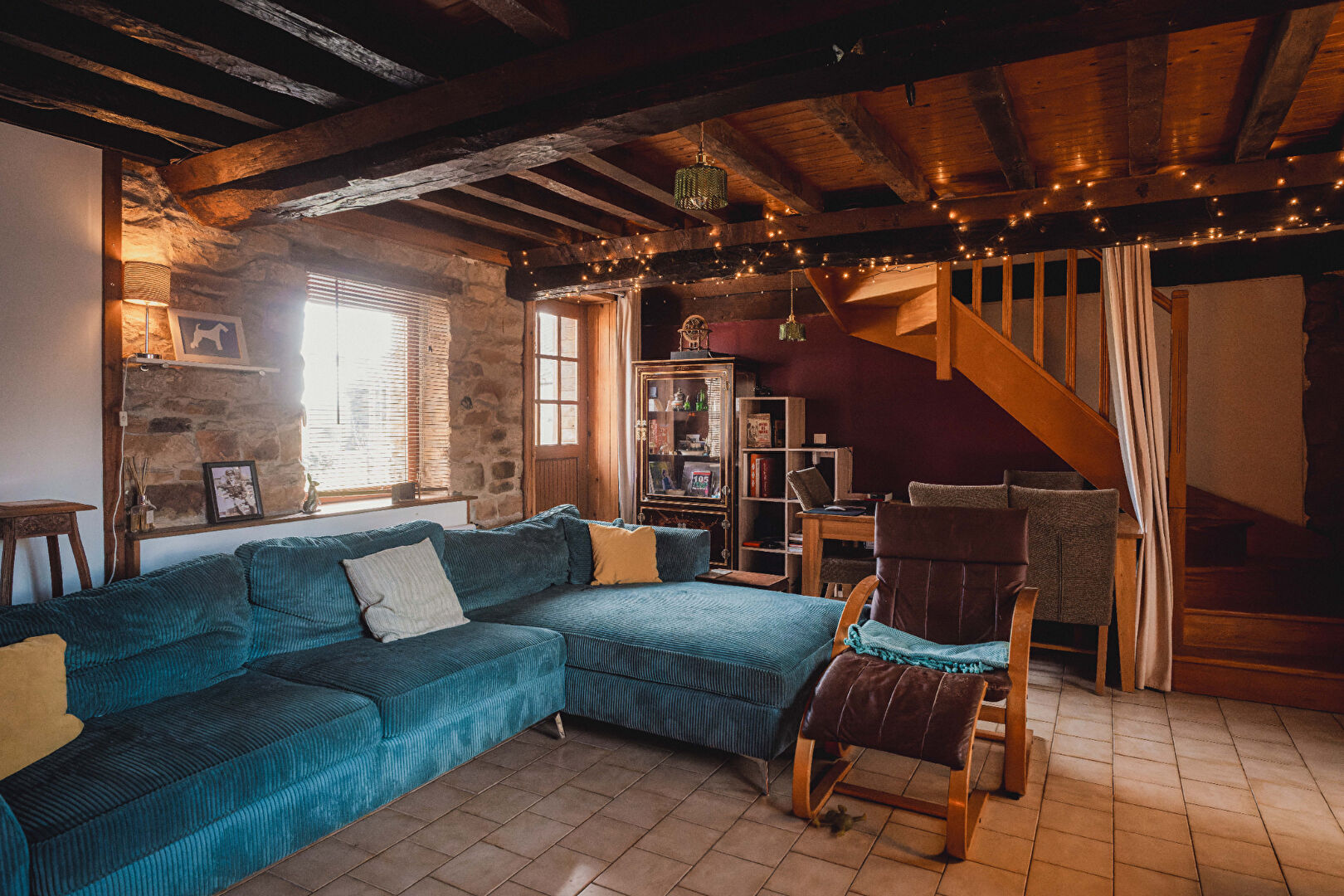 Cosy property in Orne, Normandy, featuring a spacious lounge with wooden beams and comfortable seating.