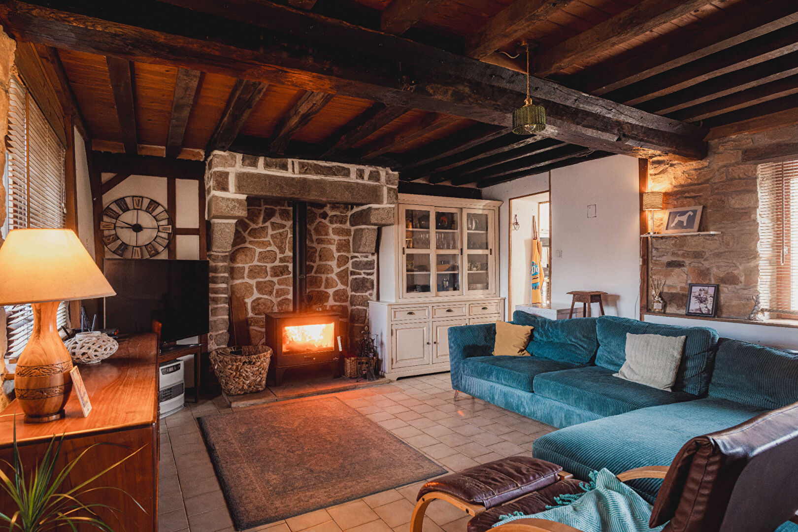 Cosy living area with exposed beams, stone fireplace, and comfortable seating in Orne, Normandy, 61700 property.