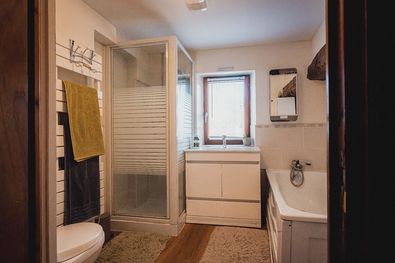 Modern bathroom featuring a shower, bathtub, and sleek vanity in Orne, Normandy, 61700.