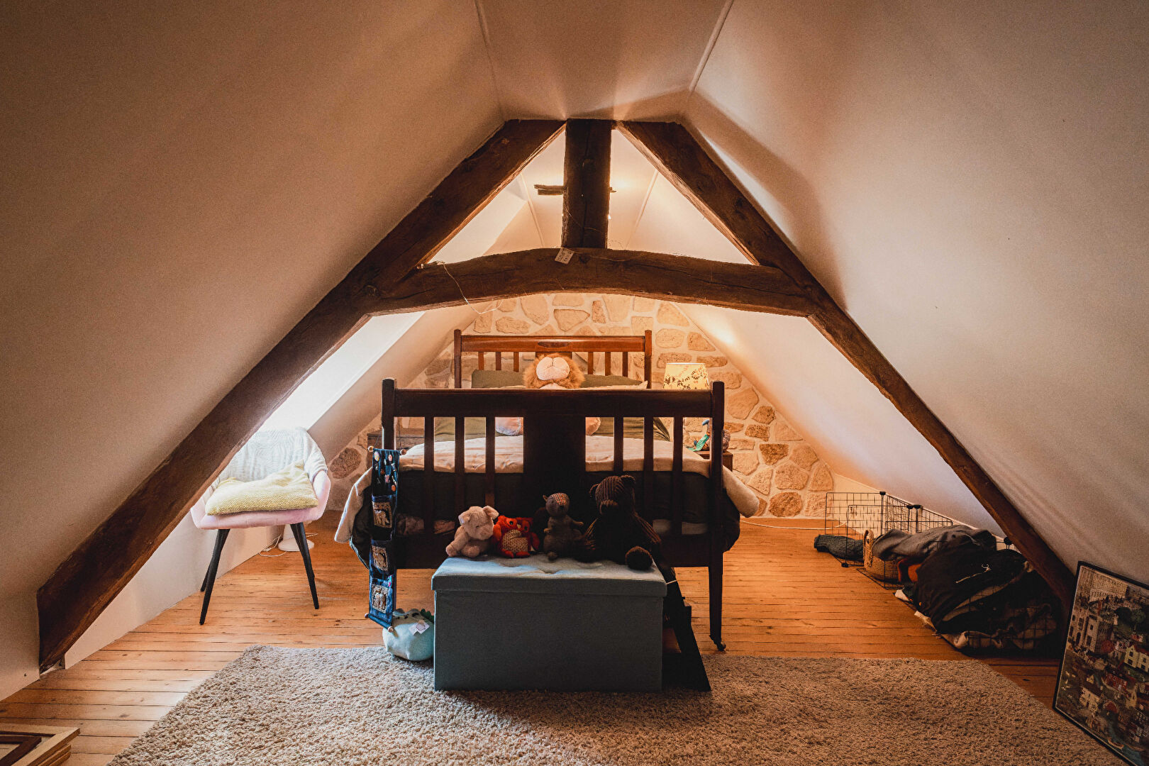 Cosy two-bedroom property in Orne, Normandy, featuring a wooden beam ceiling and charming decor in the attic space.