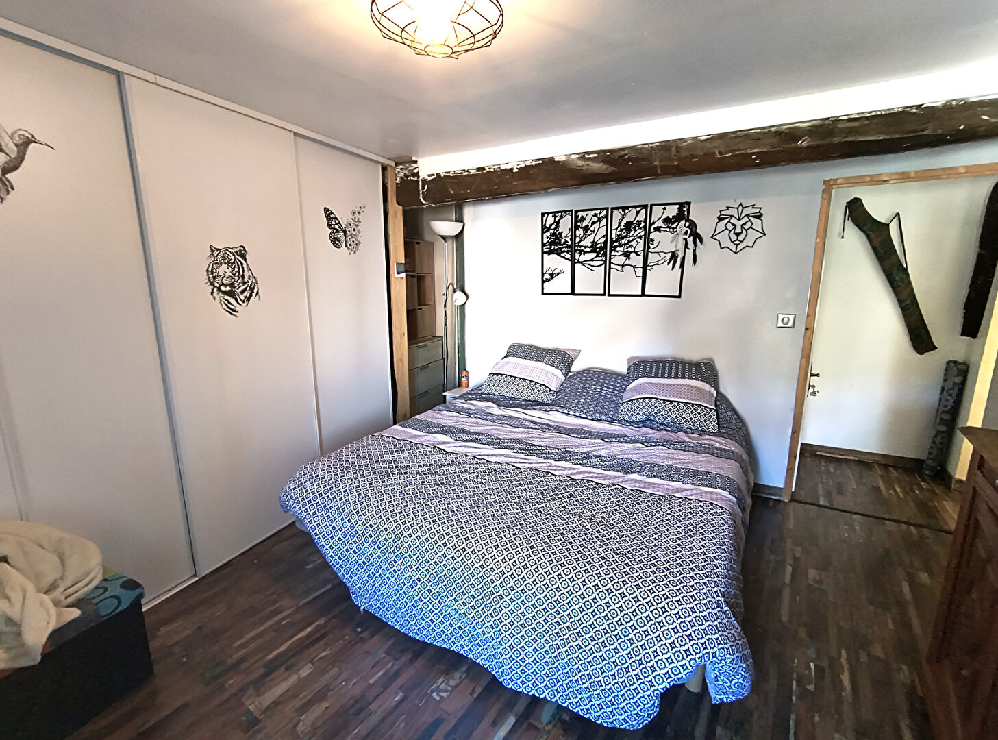 Spacious bedroom with decorative wall art, located in Haute-Vienne, Nouvelle-Aquitaine, featuring a double bed and storage.