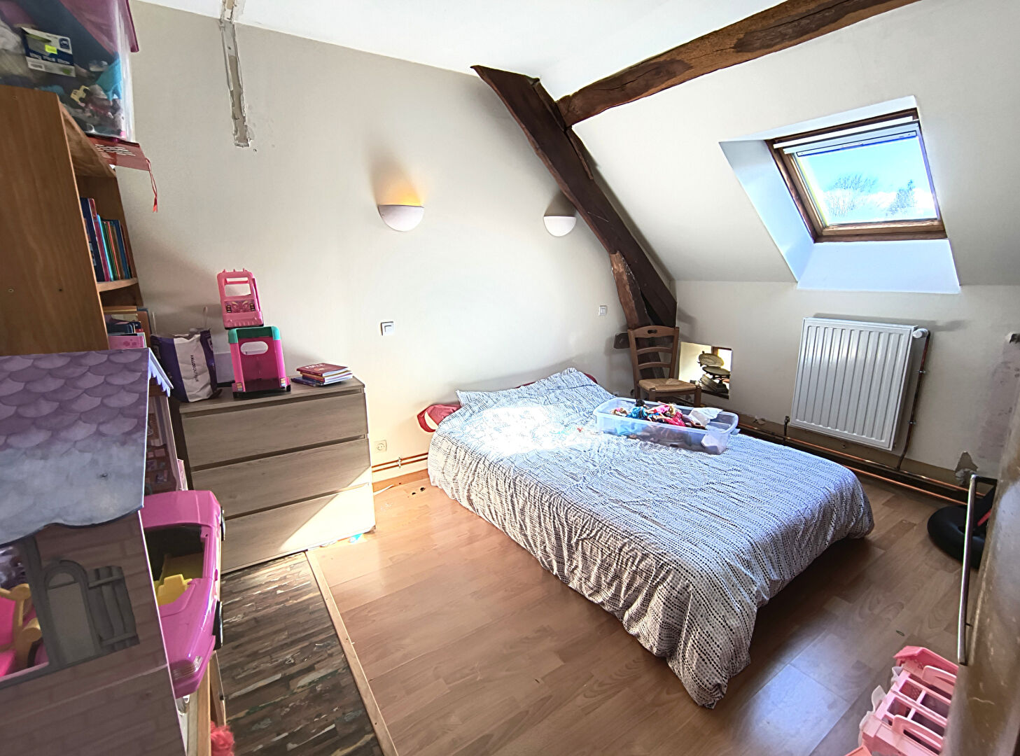 Spacious bedroom in a property in Haute-Vienne, Nouvelle-Aquitaine, featuring wooden beams and natural light.