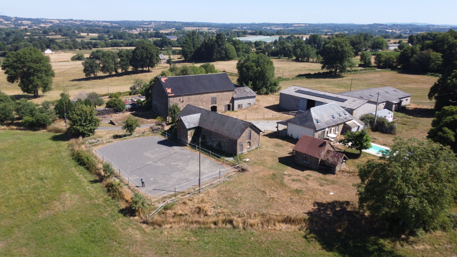 Rural property in Corrèze, Nouvelle-Aquitaine, featuring multiple buildings and open land with scenic views.