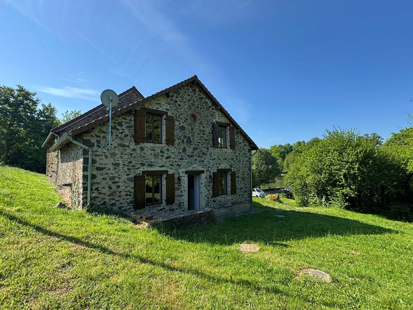 Stone house in Haute-Vienne, Nouvelle-Aquitaine, surrounded by greenery and open space, featuring traditional architecture.