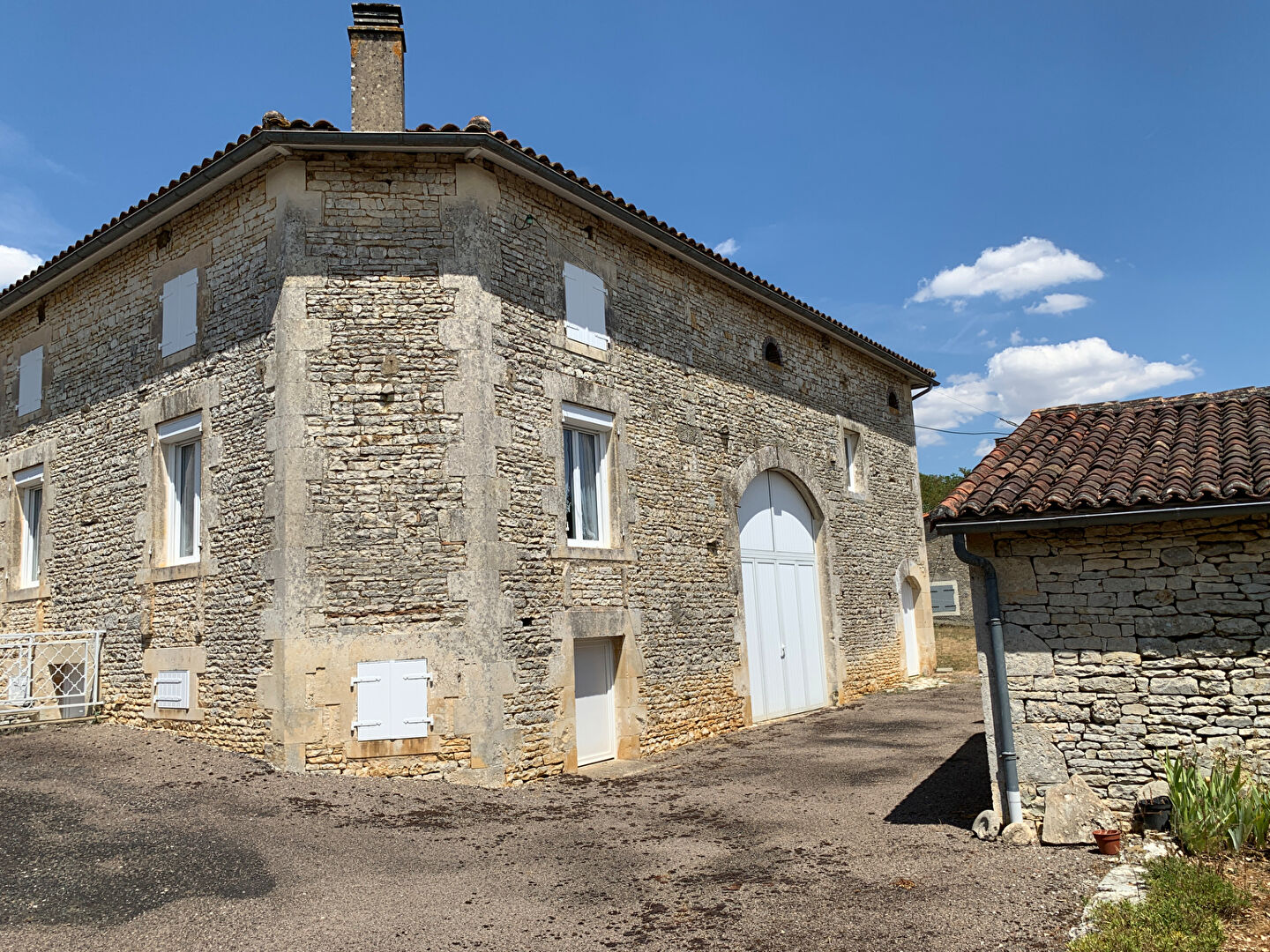 Stone property in Charente, Nouvelle-Aquitaine, featuring a large entrance and a spacious exterior area.