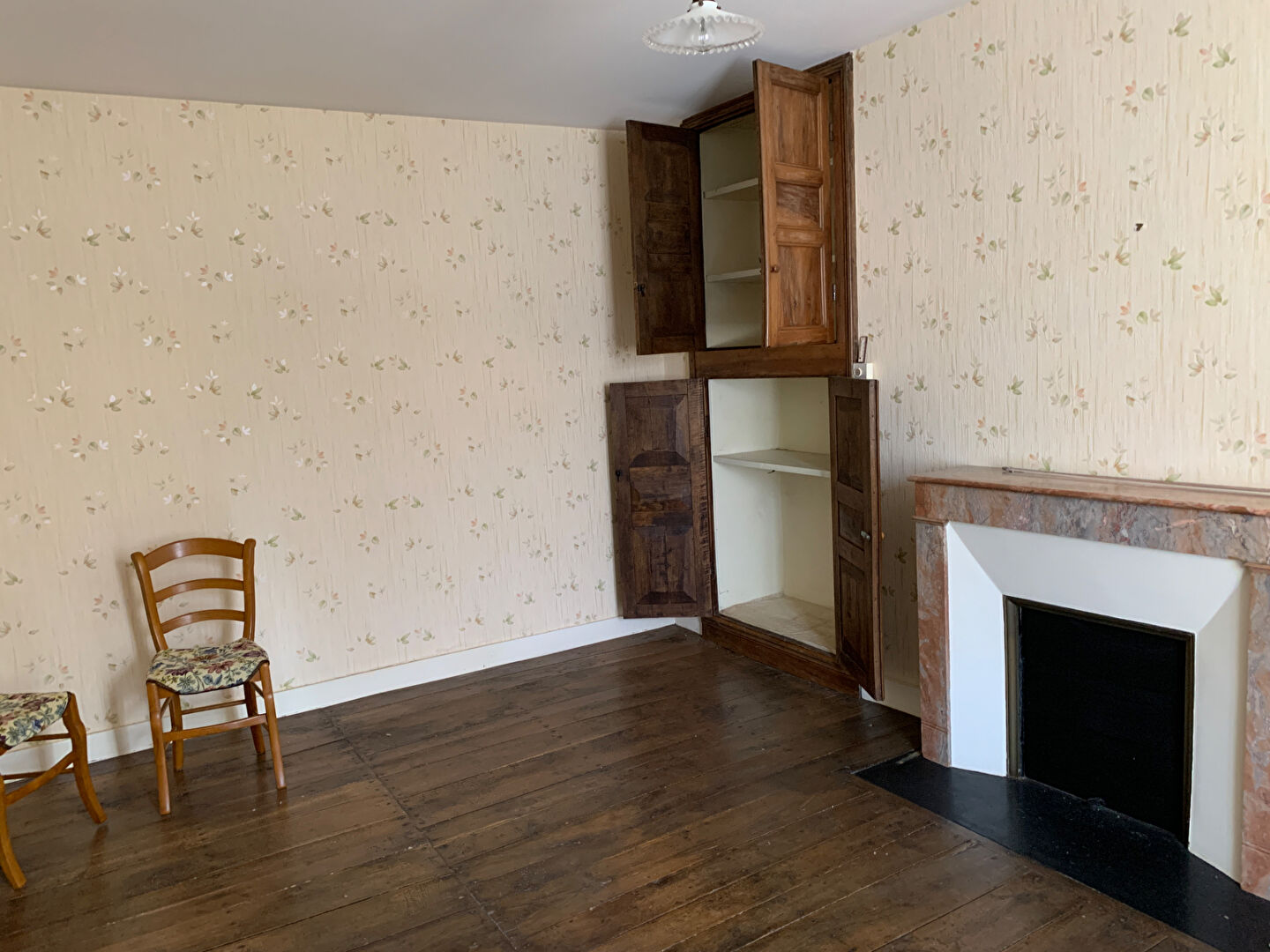 Spacious interior of a property in Charente, Nouvelle-Aquitaine, featuring traditional wooden elements and a fireplace.