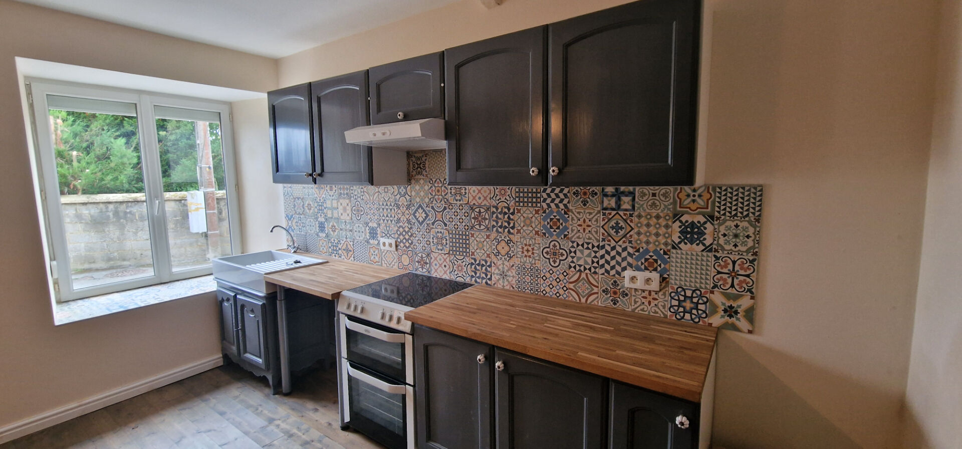 Modern kitchen in a property located in Morbihan, Brittany, featuring wooden worktops and patterned tiles.