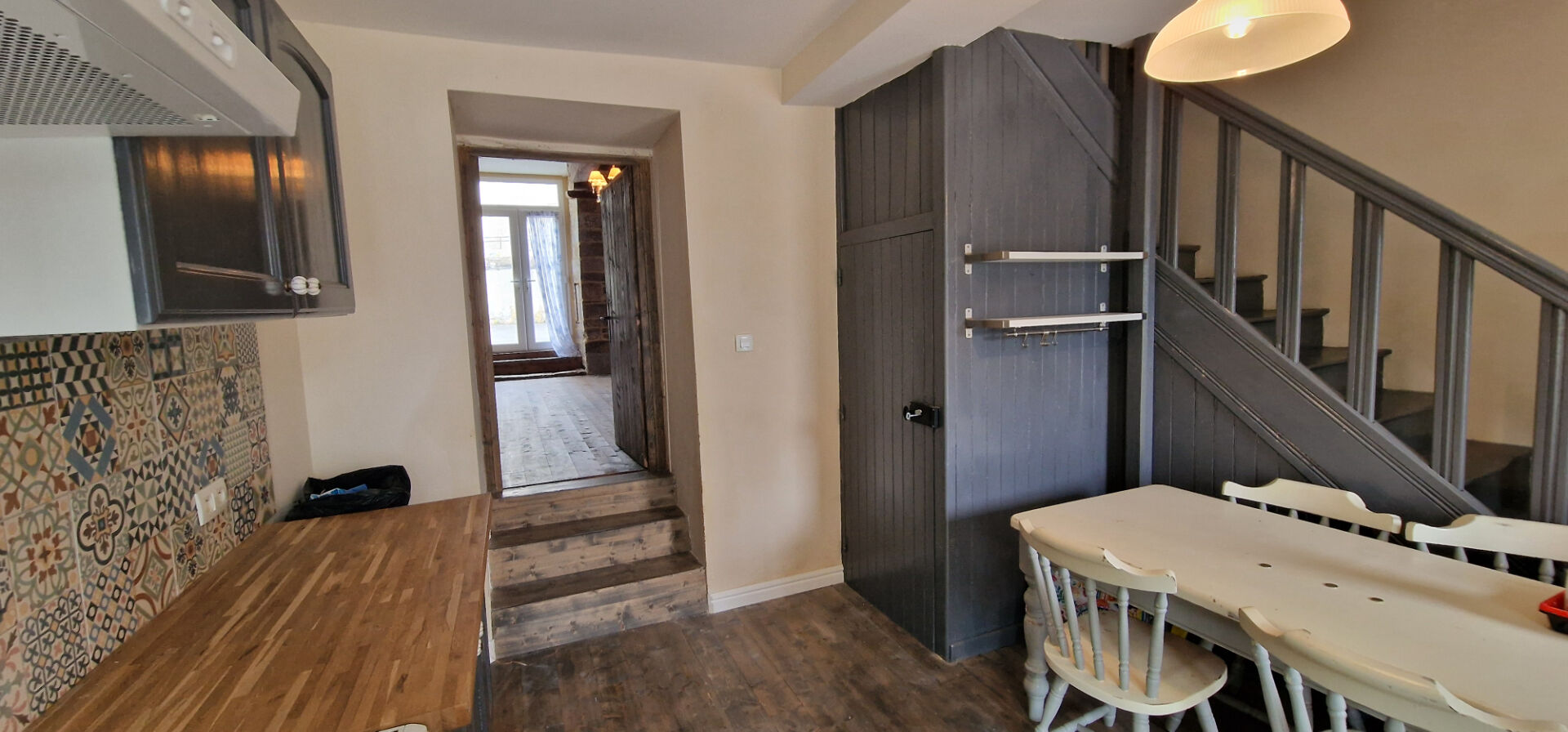 Charming property in Morbihan, Brittany, featuring a spacious kitchen and dining area, with wooden accents and stairs.