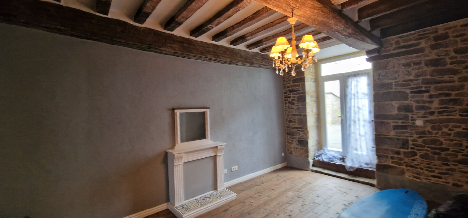 Three-bedroom property in Morbihan featuring exposed beams, stone walls, and a bright window.