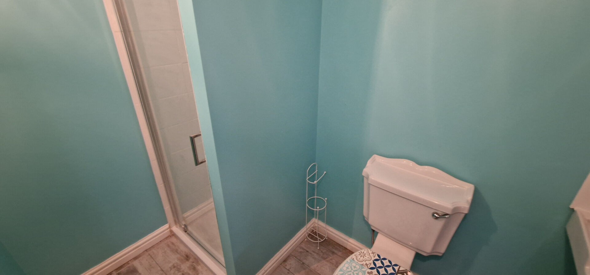 Bright bathroom featuring a shower, toilet, and aqua walls in Morbihan, Brittany, 56490.