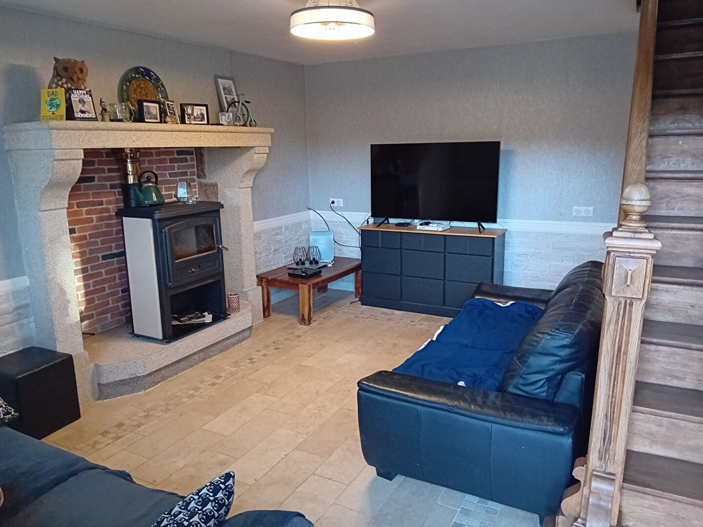 Spacious property in Creuse featuring a cosy living area with a fireplace and modern television setup.
