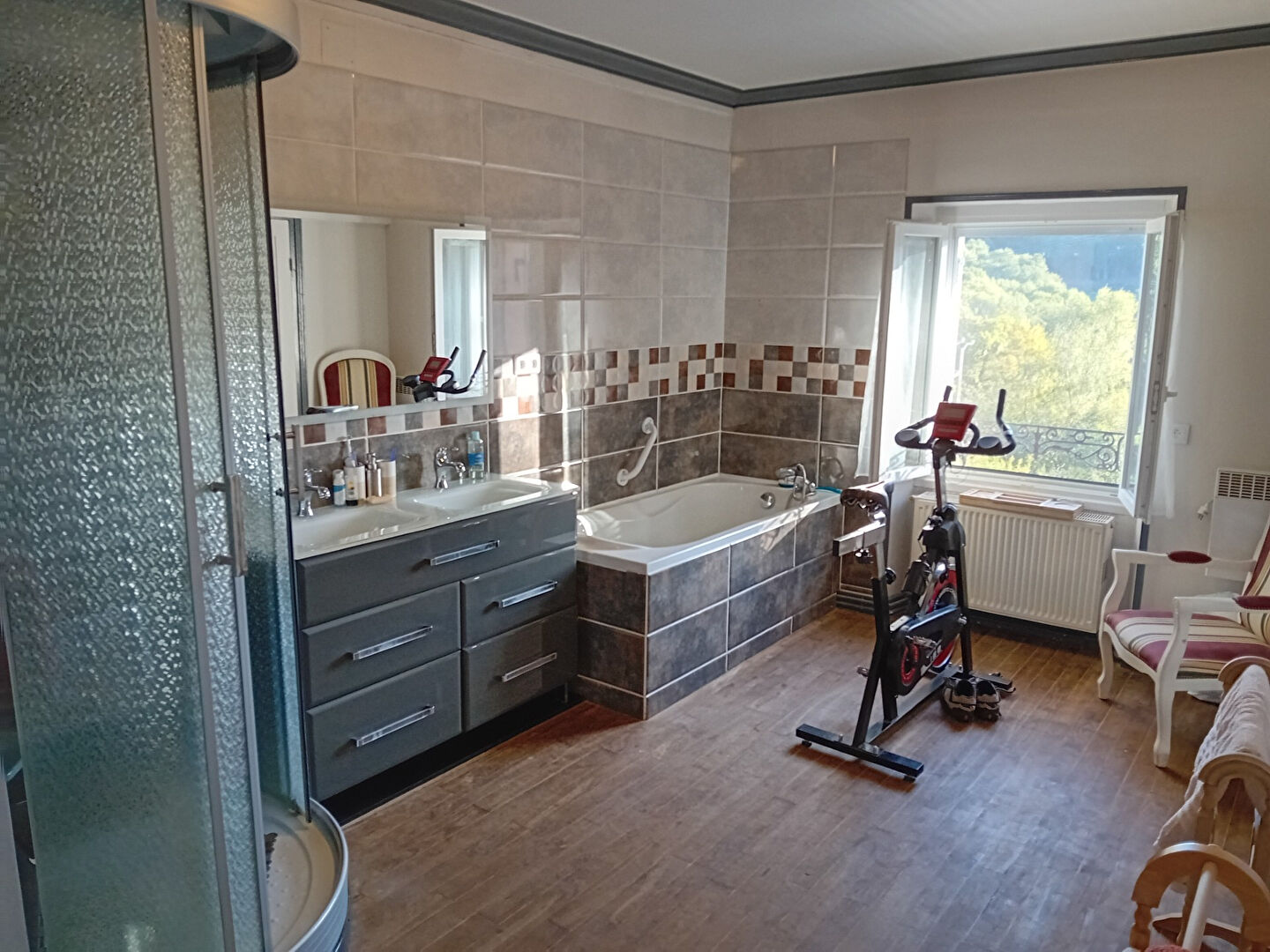 Spacious bathroom featuring a shower, bathtub, and window view in a property in Creuse, Nouvelle-Aquitaine.