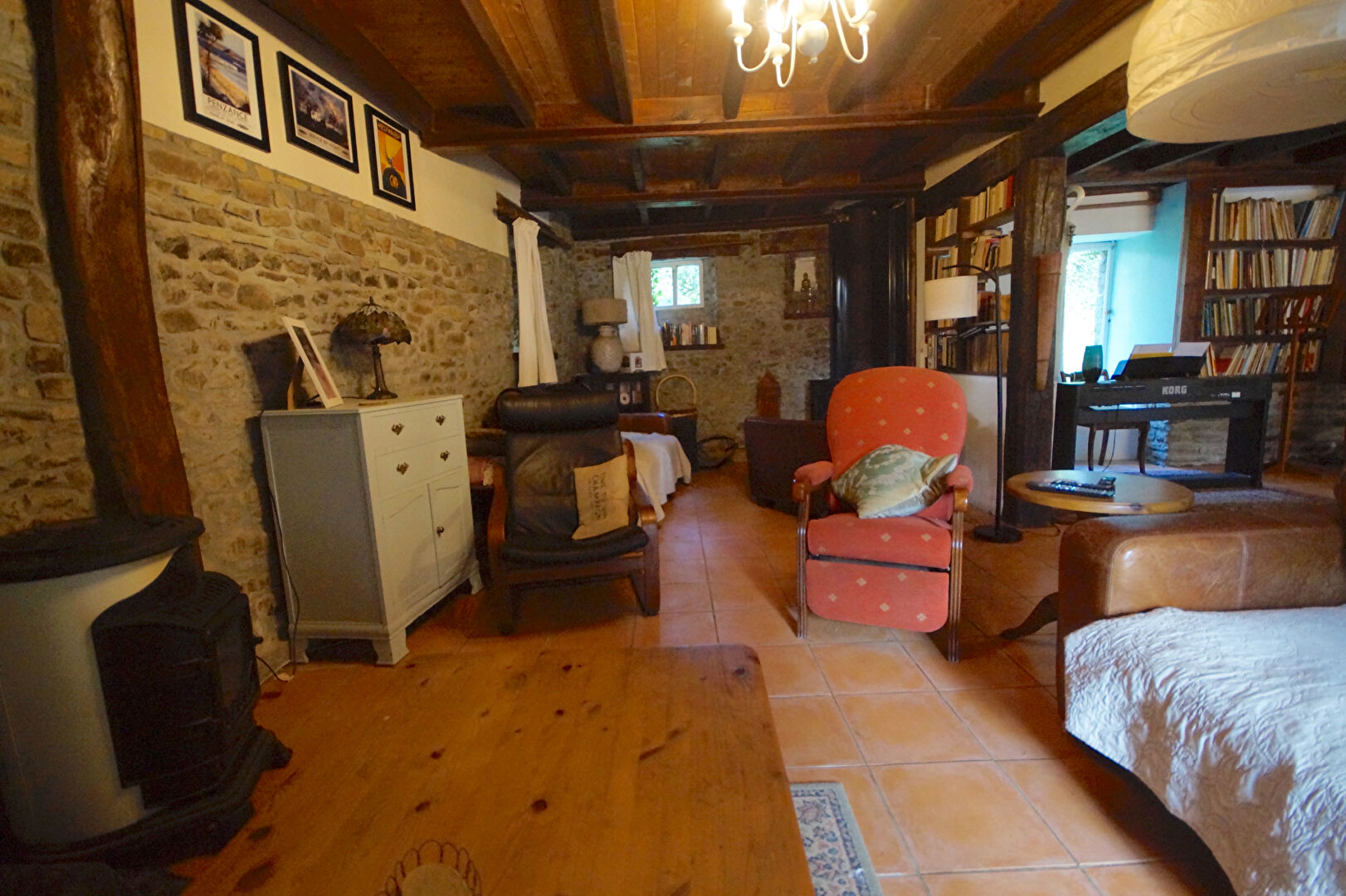 Cosy interior of a property in Manche, Normandy, featuring wooden beams and a warm, inviting atmosphere.