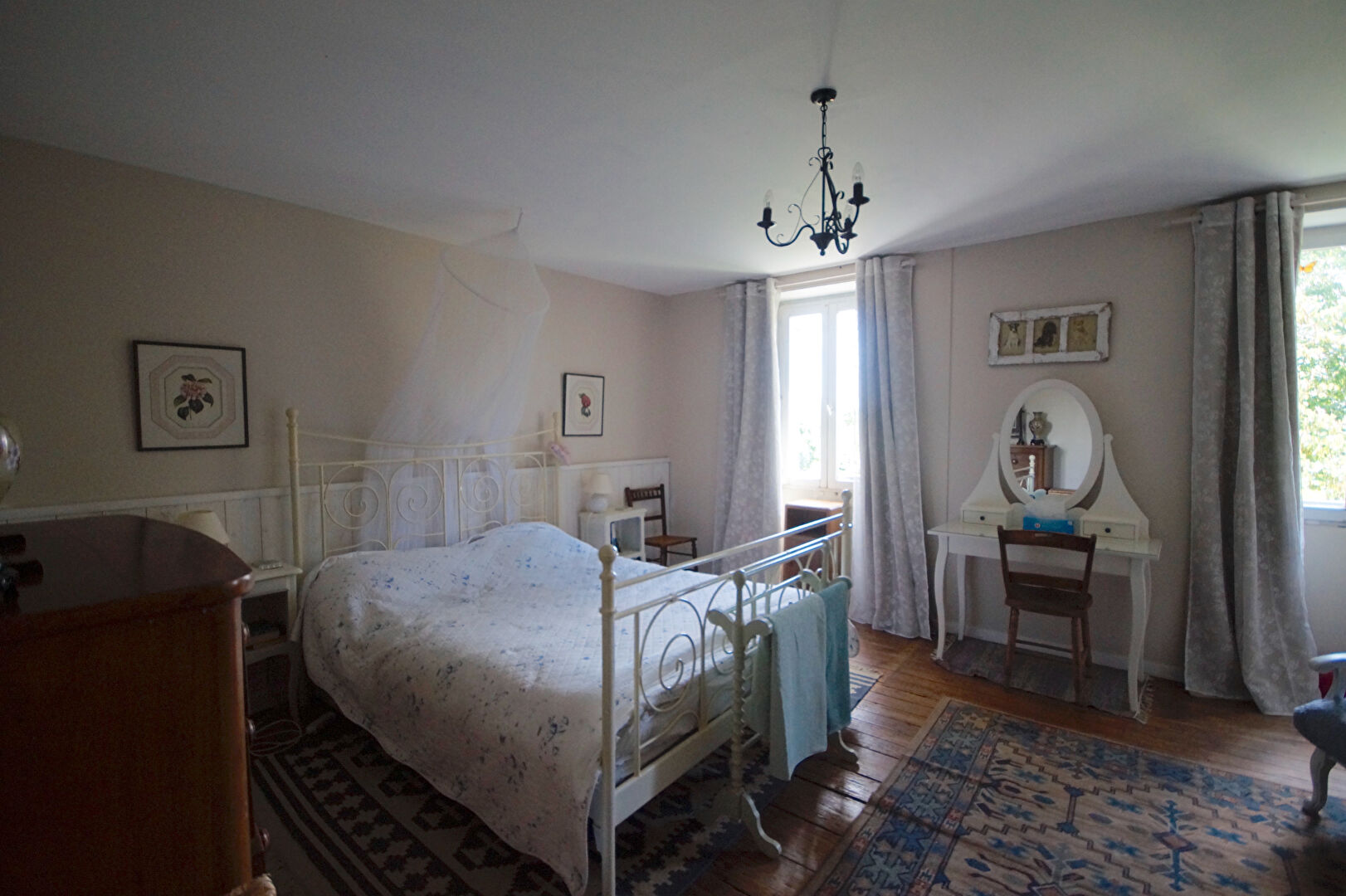 Spacious bedroom in a property located in Manche, Normandy, featuring a vintage bed and elegant decor.