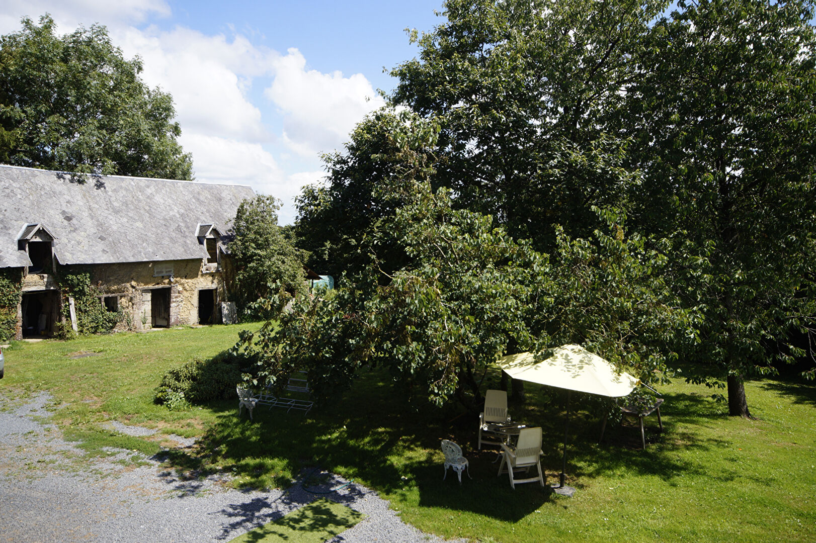 Spacious property with garden and outdoor seating in Manche, Normandy, featuring a charming rustic building.